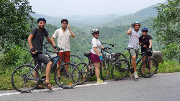 Rajasthan per Rad entdecken Radreise Rundreise Radfahrer machen Pause in Indien, 5 Personen, Palmen, Blick ins Tal