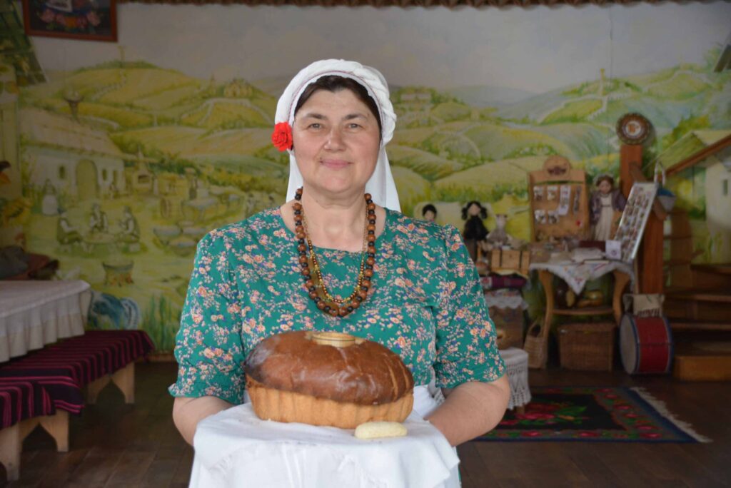 Moldawien, Foto zeigt Frau in einheimischer Tracht die Brot überreicht